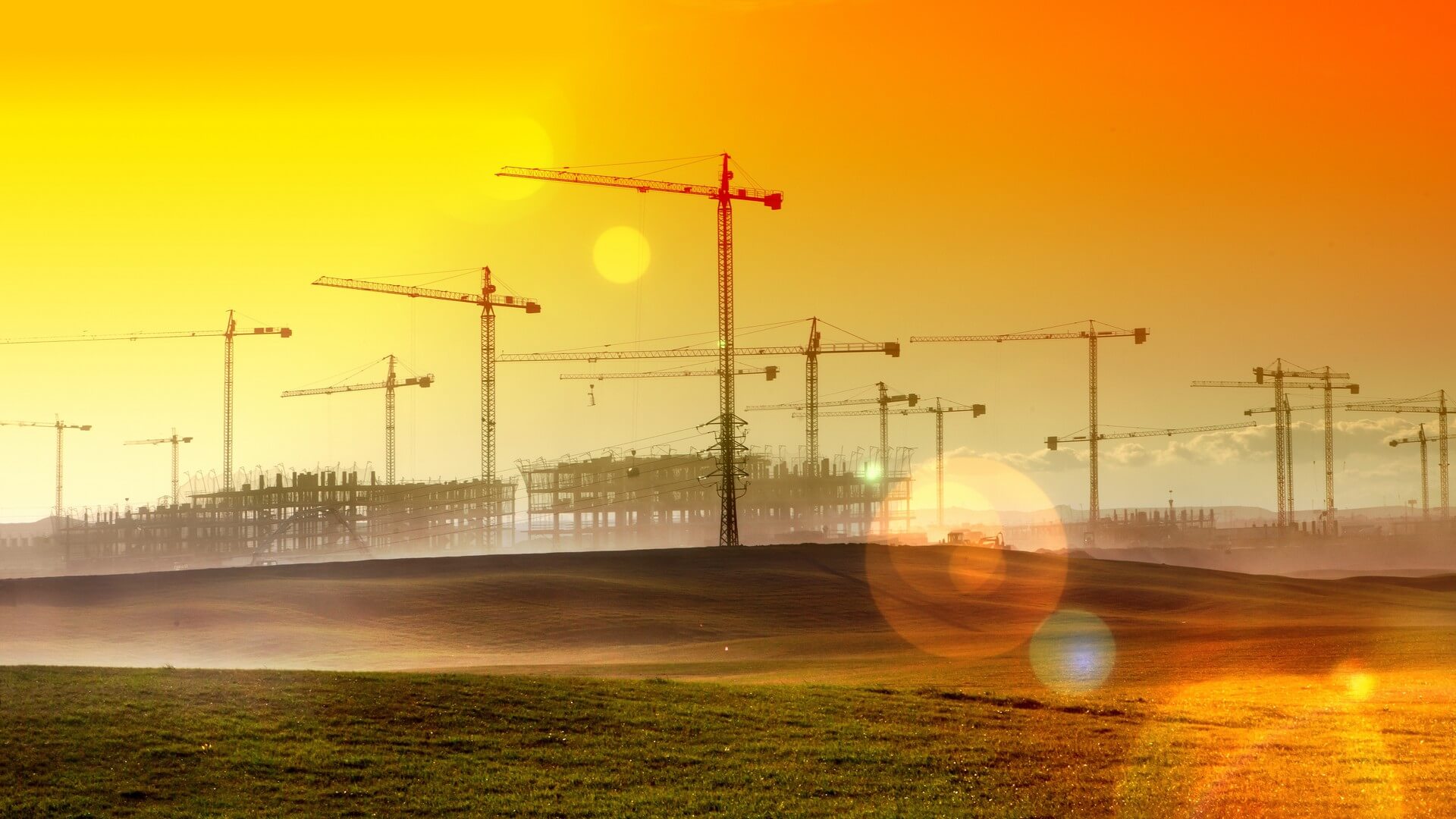 Paisaje de atardecer.Gruas y edificios en construccion